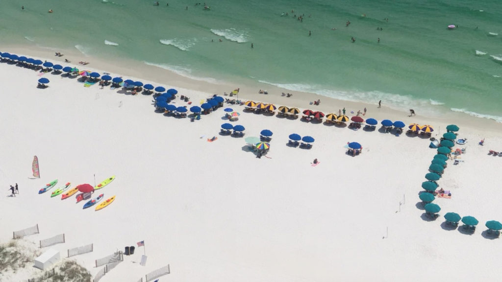 Beach service umbrellas lined up along beach in Destin, FL